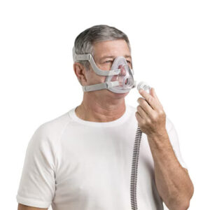 Barbat cu Masca CPAP full-face AirFit F20 oronazala, Resmed exemplificand sistemul de prindere furtun