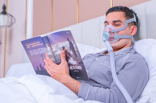 Barbat citind in pat cu Masca CPAP oronazala, Full Face, F5A+, BMC Medical