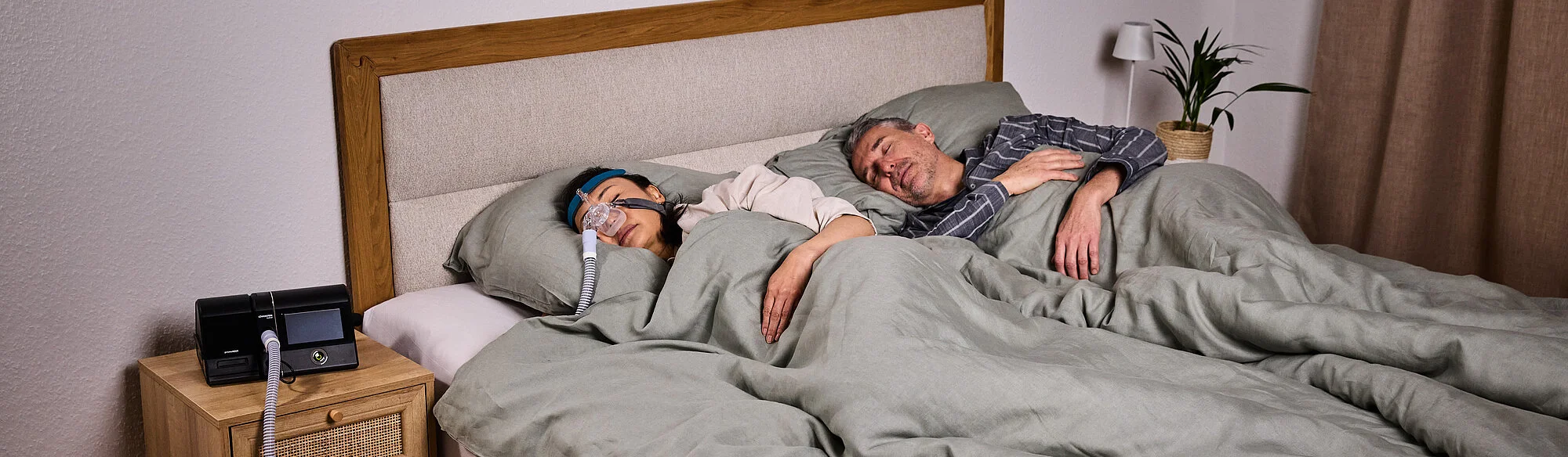 alergii si apnee in somn, cuplu adult dormind, femeie tanare cu aparat si masca petnru apnee